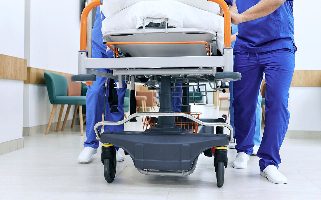 Wheeling patient bed through hospital corridor