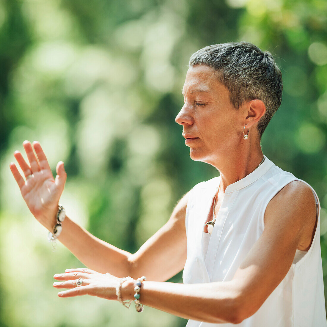 Woman practicing qigong in a forest