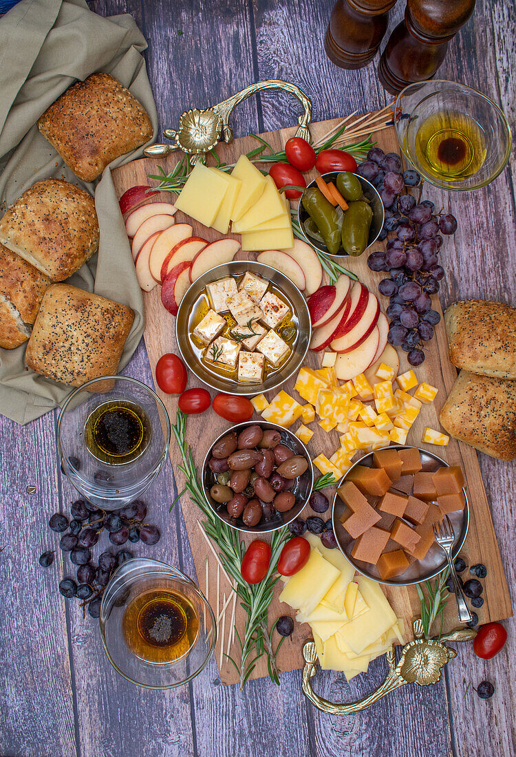 Käsebrett mit Obst, Oliven, Weintrauben und Brot