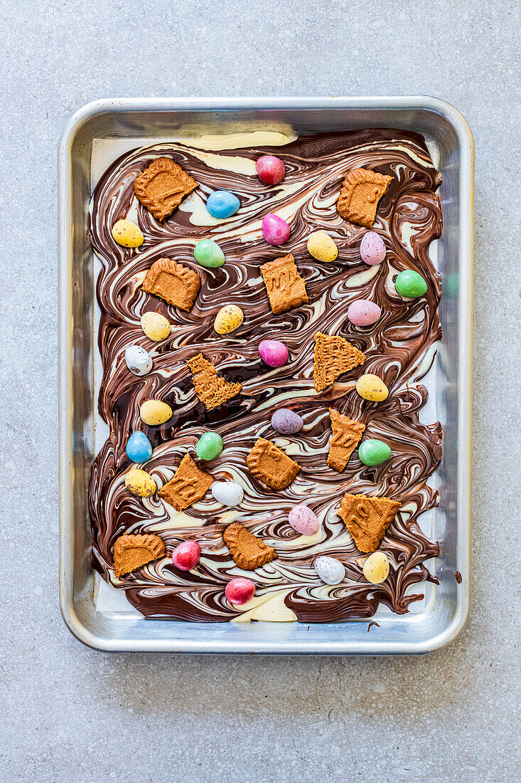 Swirled chocolate with white and dark chocolate, mini Easter eggs and broken cookies