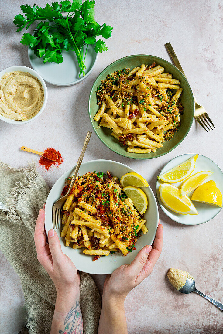 Creamy hummus pasta with crunchy crumbs, dried tomatoes and lemon