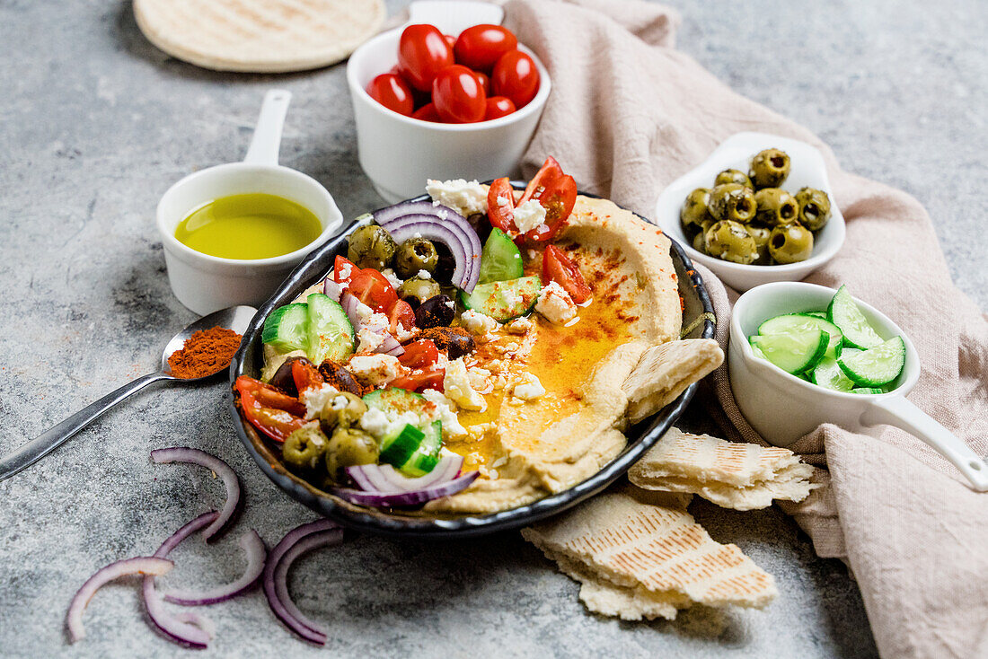 Loaded hummus platter with feta, tomatoes, cucumber, olives, and onions