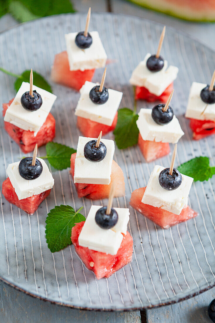 Appetizer platter with watermelon, feta, blueberries and mint skewers