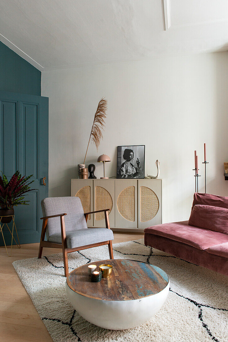 Living room with pink velvet sofa, armchair, round coffee table and fluffy rug