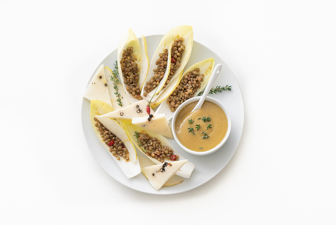 Linsensalat serviert in Chicoreeblättern mit Birne und Käse