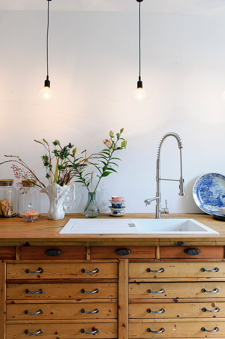 Kitchen unit with wooden drawers and pendant lights