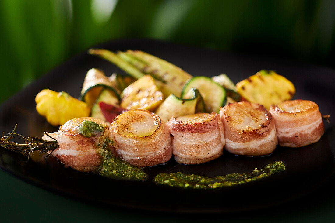 Scallops wrapped in bacon with grilled vegetables