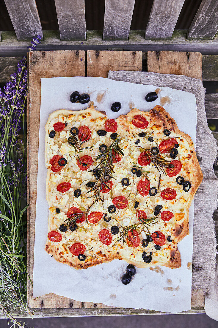 Greek tarte flambée with tomatoes, feta, and olives