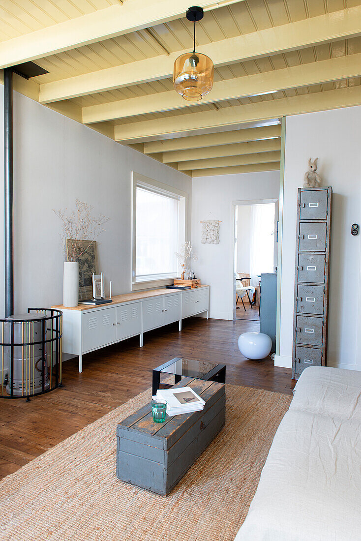 Living room with ceiling beams, sideboard, locker and wooden chest as a coffee table