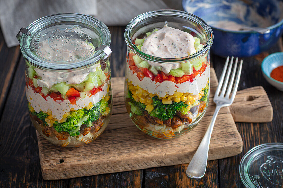 Layered salad with chicken, broccoli, pasta and corn