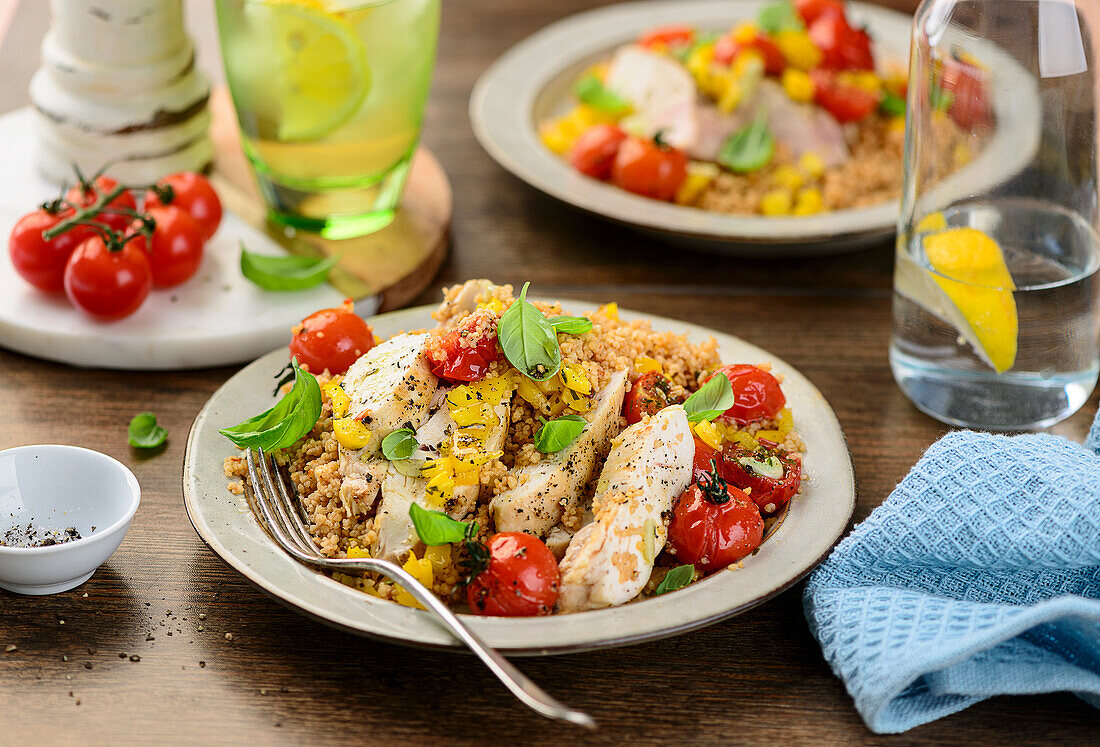 Gebratenes Hähnchen auf Couscous mit Paprika und Tomaten aus dem Ofen