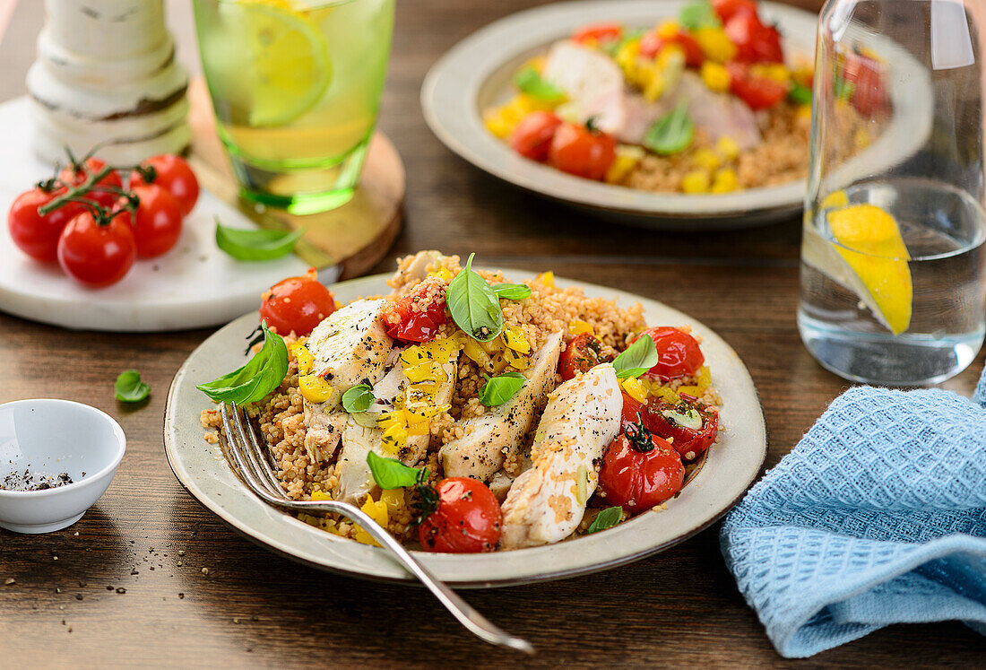 Roasted chicken on couscous with peppers and tomatoes from the oven