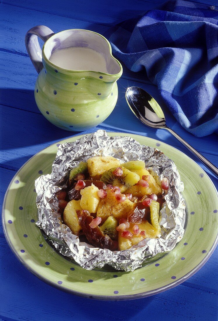 Exotic fruits baked in aluminium foil with vanilla sauce