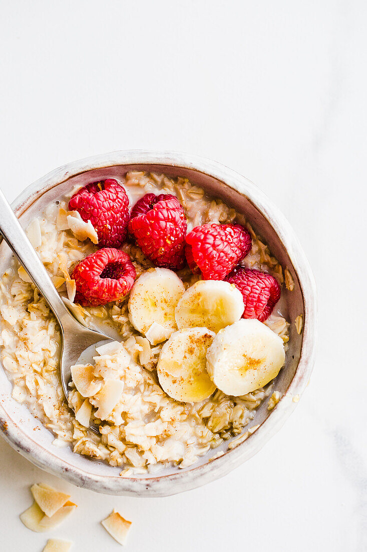 Oatmeal Bowl mit Himbeeren, Bananen und Kokosflocken