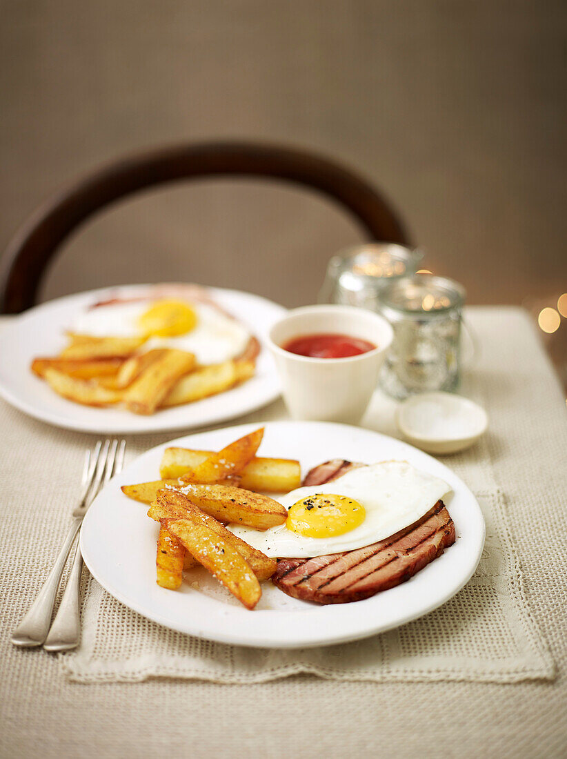 Grilled ham with fried eggs and potato wedges