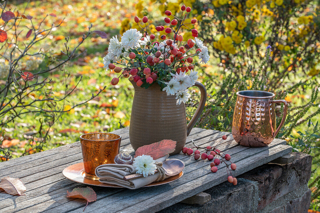 Autumn garden table with bouquet of ornamental apple and chrysanthemum (Chrysanthemum)