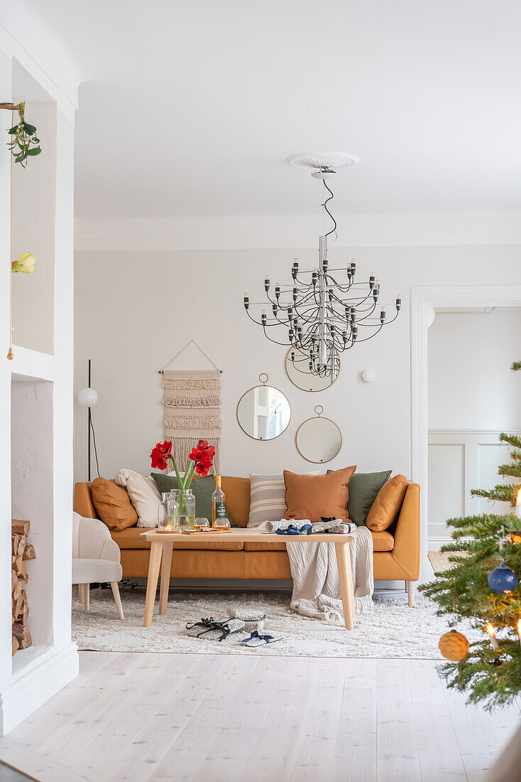 Living room with brown sofa, chandelier and Christmas tree