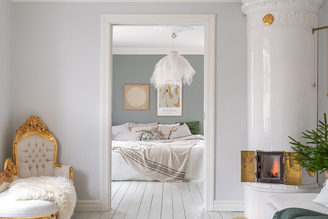 Fireplace and baroque armchair, view through open door to bedroom