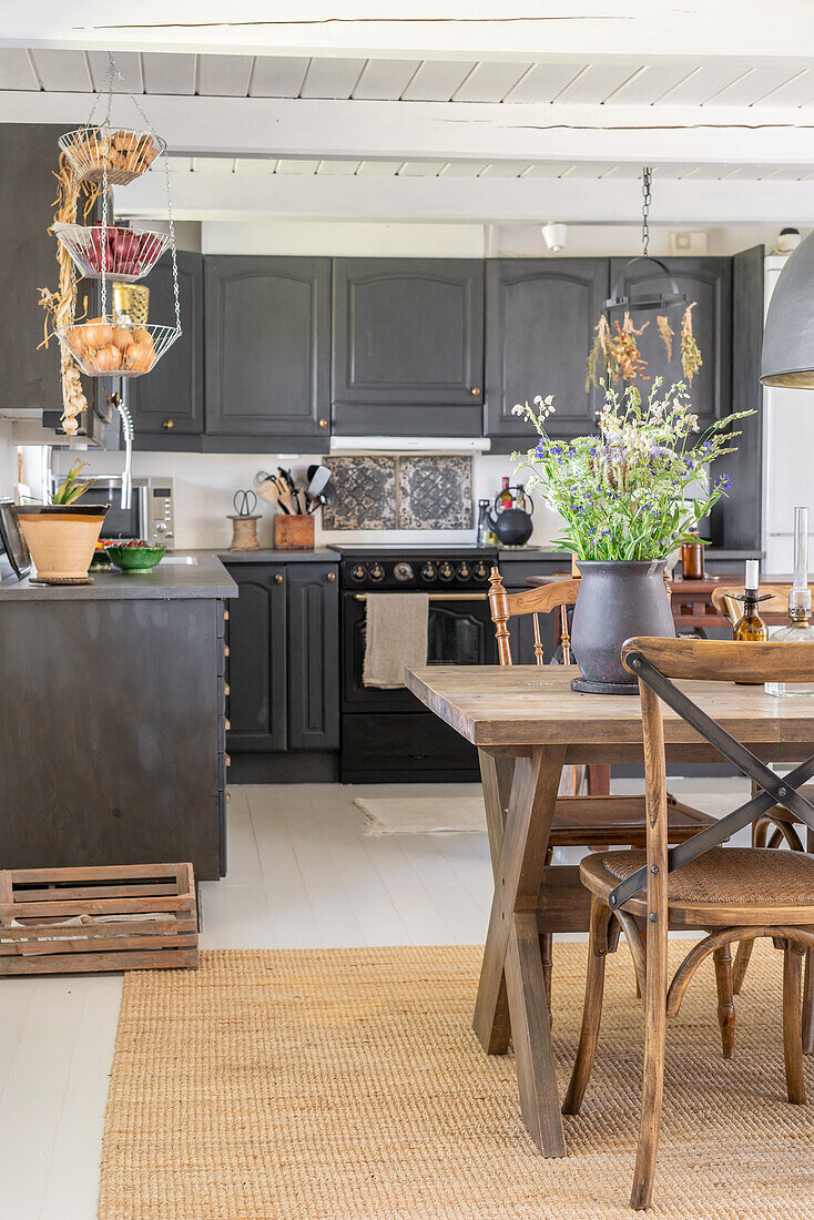 Country kitchen with dark grey cabinets and rustic dining table