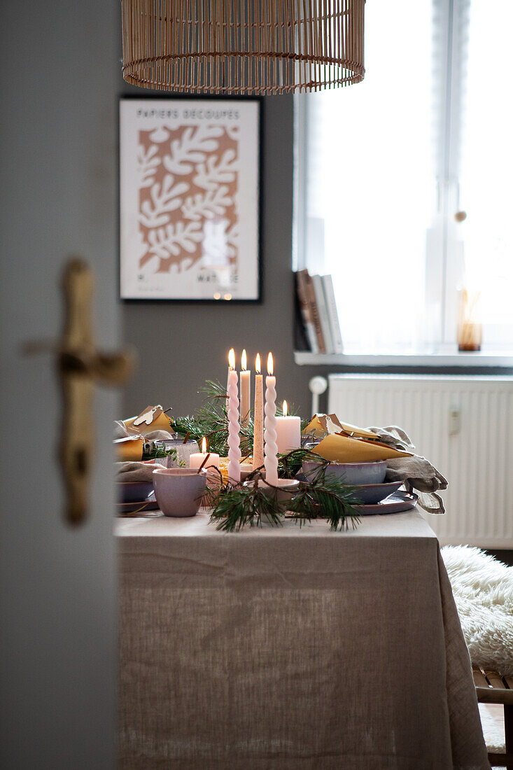 Table set with candles and fir branches, linen tablecloth