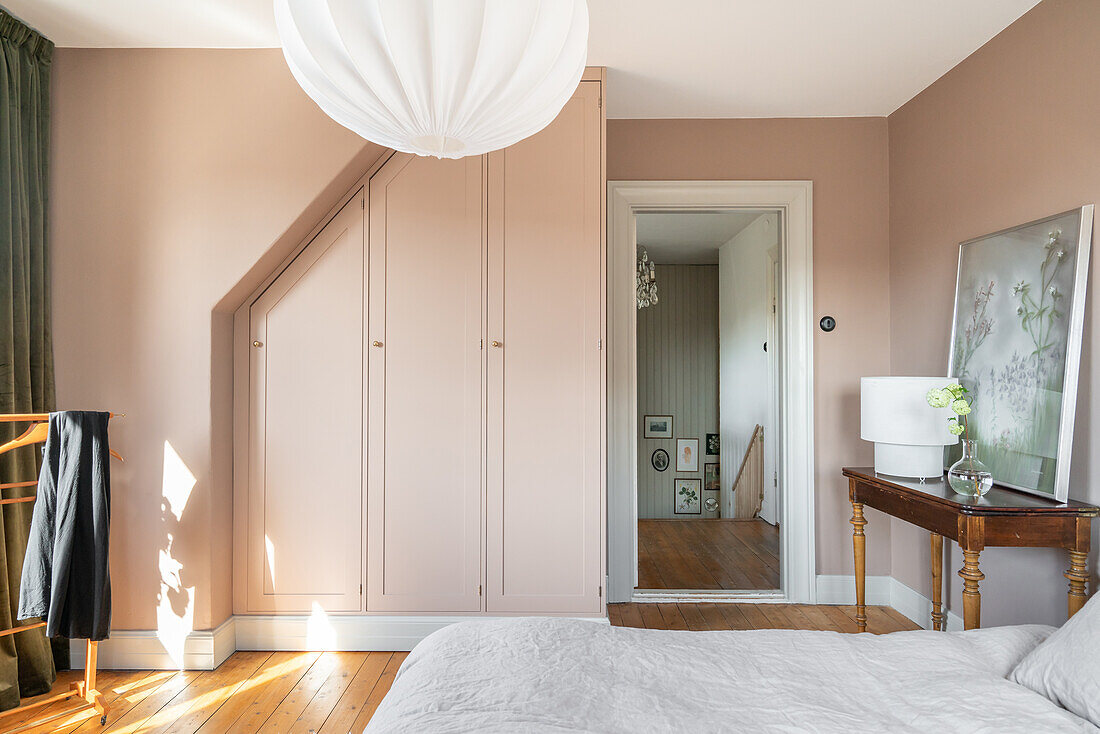 Bedroom with built-in wardrobe and walls in beige and vintage furniture