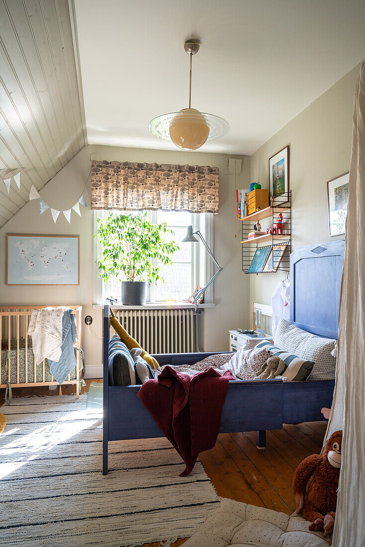 Kinderzimmer mit Bett, Wandregal, Holzfußboden und Teppich