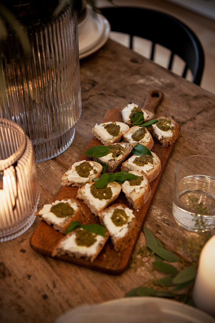 Canapés mit Frischkäse und Pesto auf Holzbrett serviert