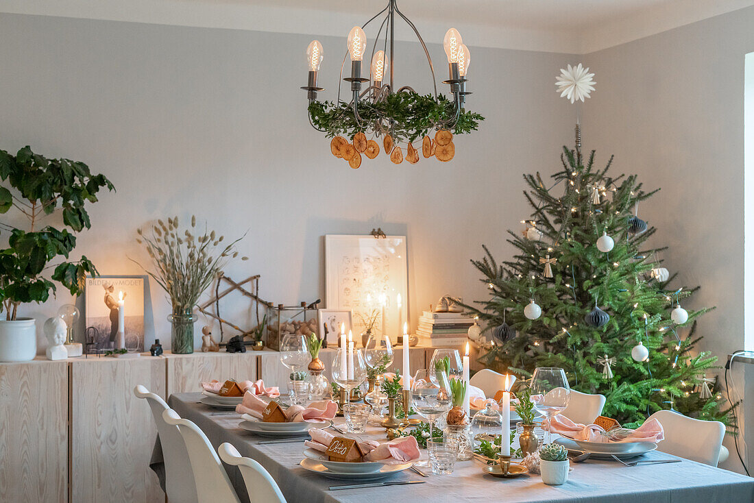 Festlich gedeckter Esstisch mit Weihnachtsbaum und Hängeleuchte