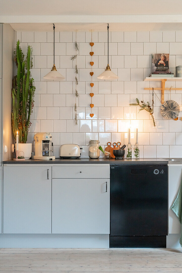 Brightly decorated kitchen unit with wall tiles, Christmas decorations and pendant lights