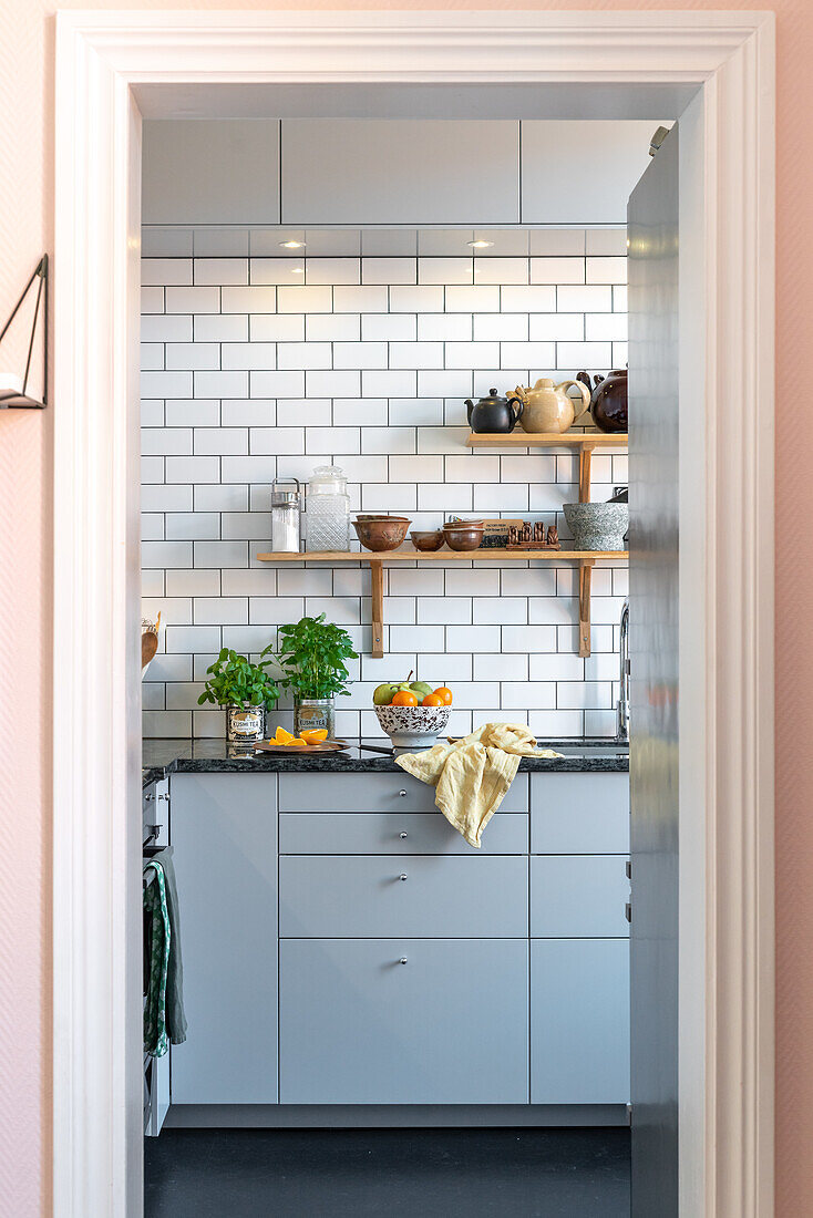 Modern kitchen with metro tiles and cabinet fronts in light grey