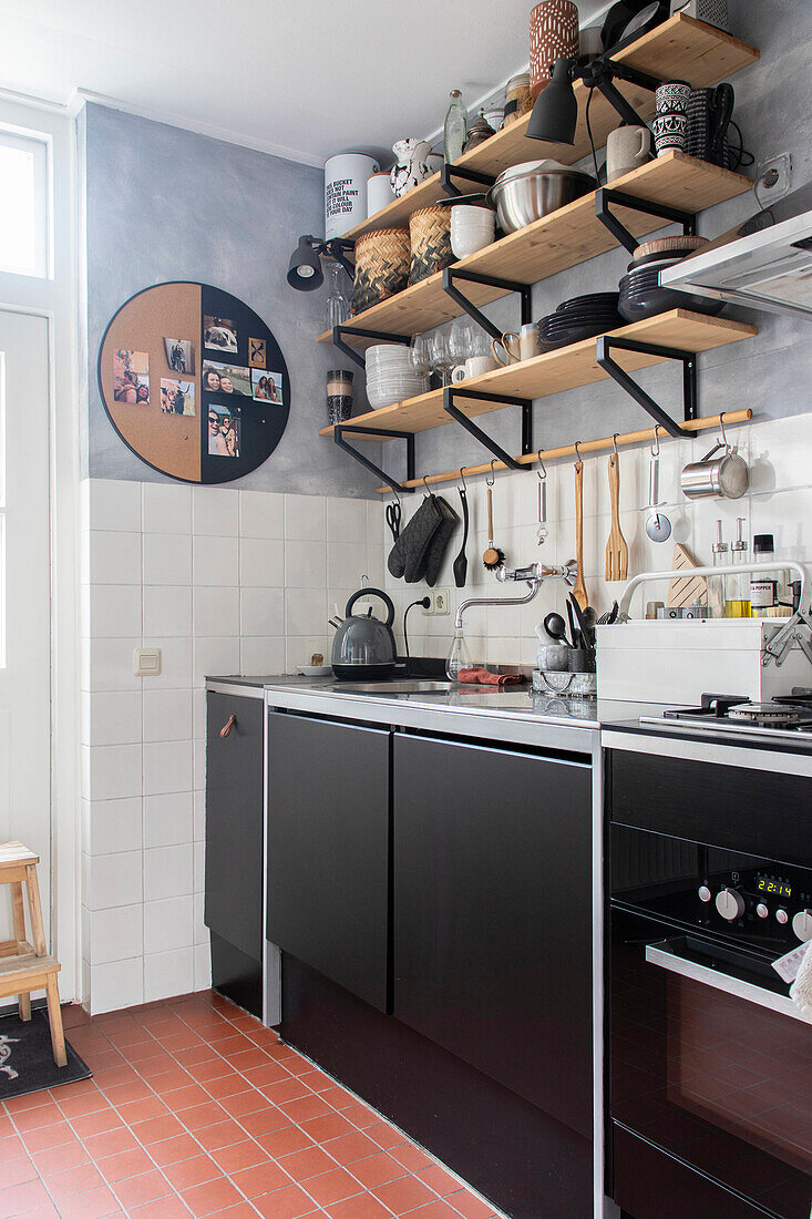 Kitchen with wooden shelves and black cupboard fronts