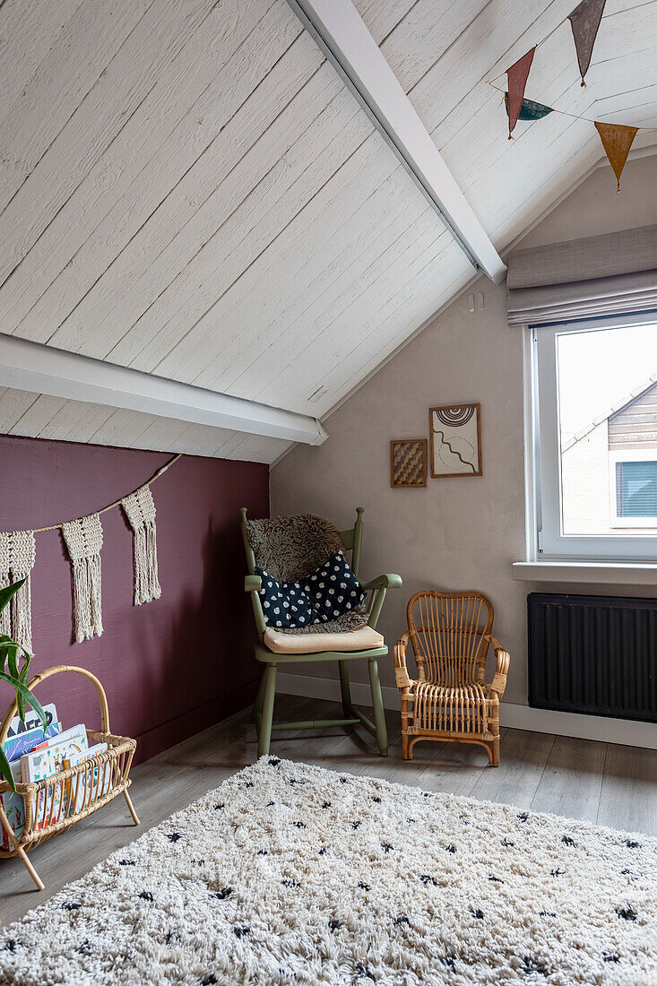 Sloping roof with reading corner, children's rattan armchair and fluffy rug