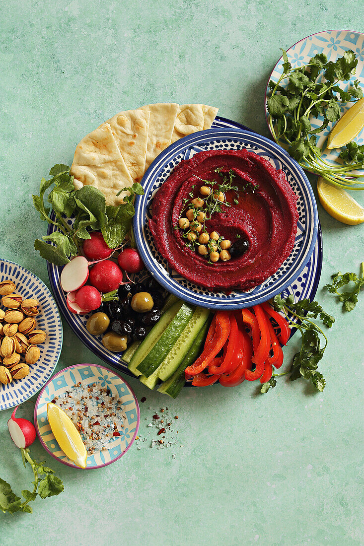 Vegan mezze plate with beetroot hummus and various vegetables