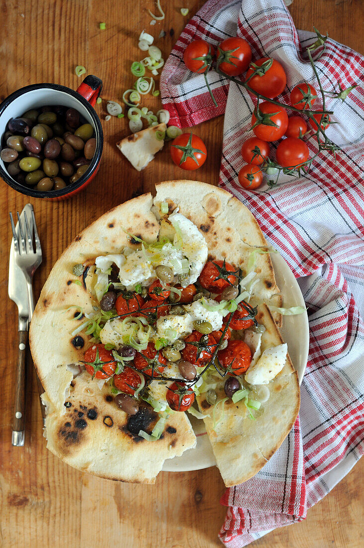 Italienisches Fladenbrot mit gerösteten Tomaten, Mozzarella und Oliven