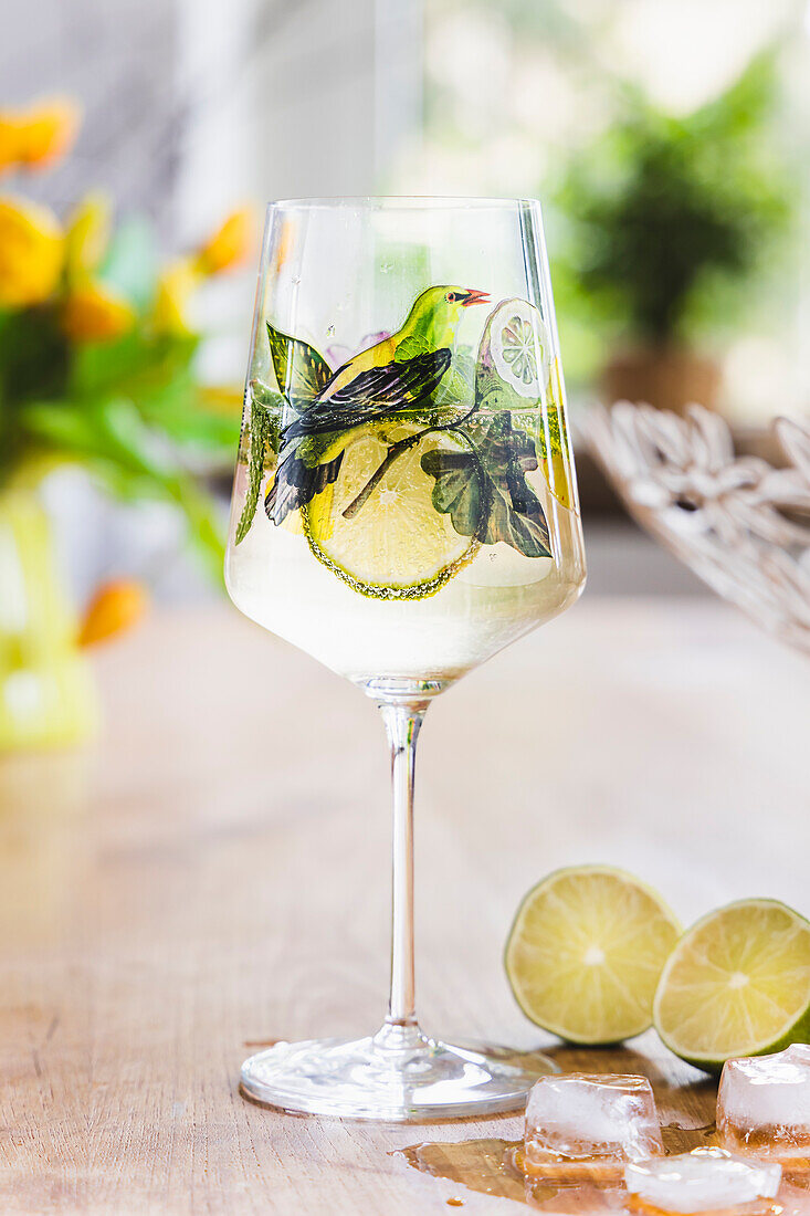 White wine in a wine glass with lime and ice cubes