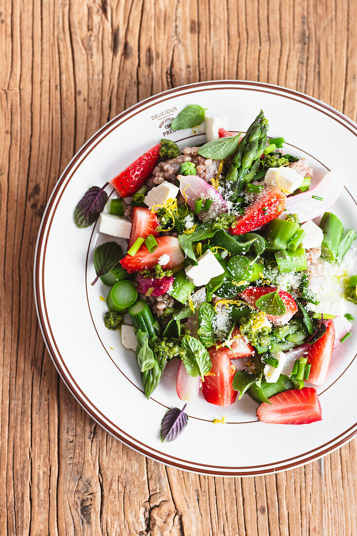 White buckwheat groats with asparagus, strawberries, feta cheese, radishes and vegetables