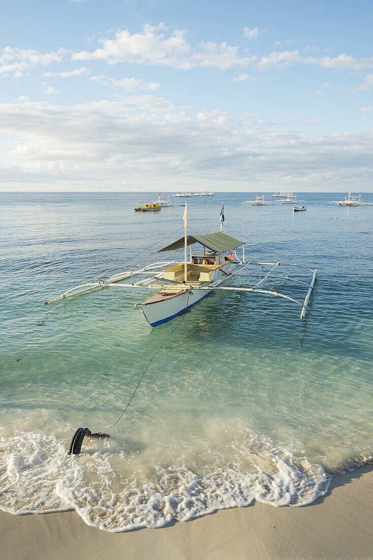 Boote auf dem kristallklaren Wasser des Alona Beach; Panglao Island, Bohol, Philippinen