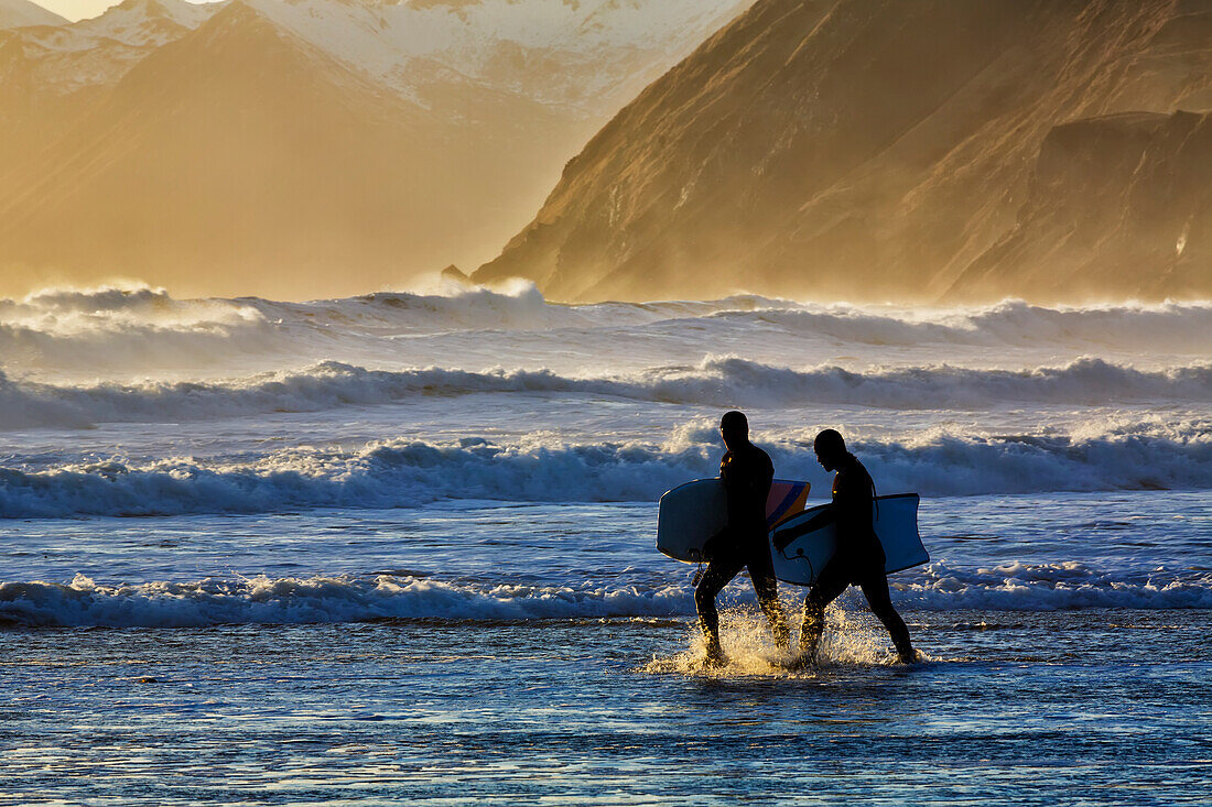Body-Surfer spazieren im Wasser an der Küste von Kodiak Island am späten Nachmittag, Pasagshak State Park, Kodiak Island, Alaska