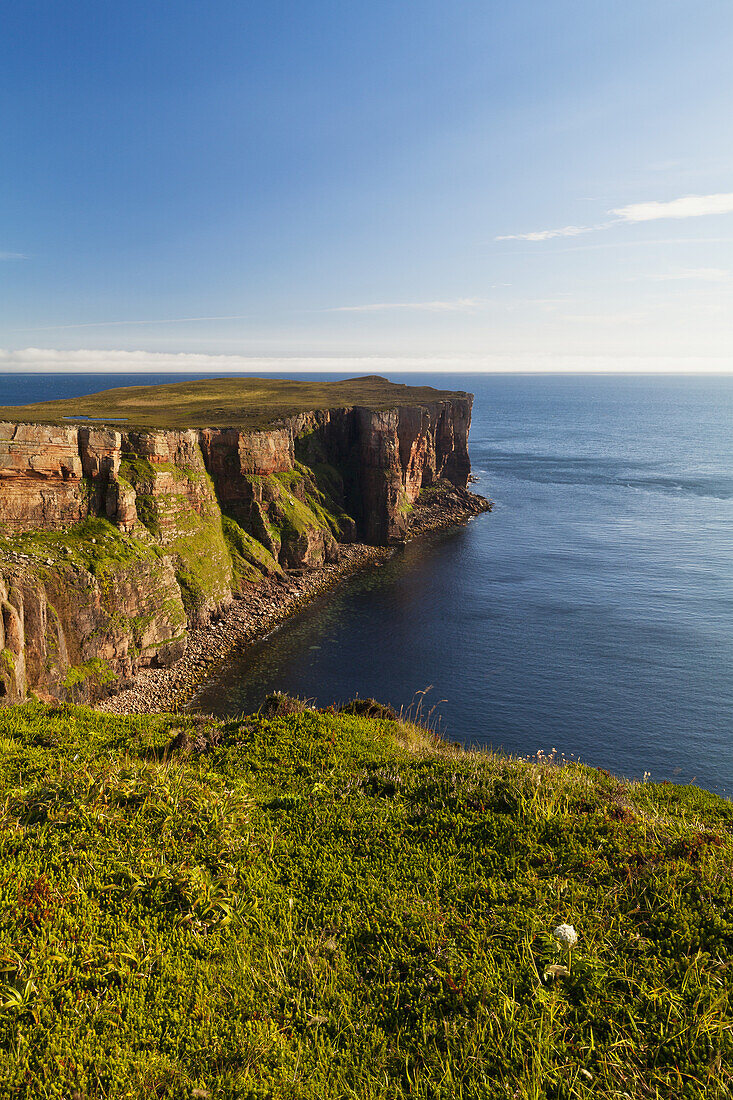 Cliff Along The Coastline And View Of The Ocean And Blue Sky; Orkney, Scotland