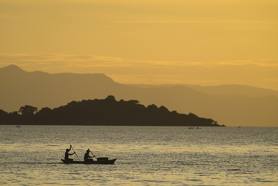 Silhouette von Fischern im Einbaum, die Cape Maclear am Abend verlassen, Malawisee; Malawi