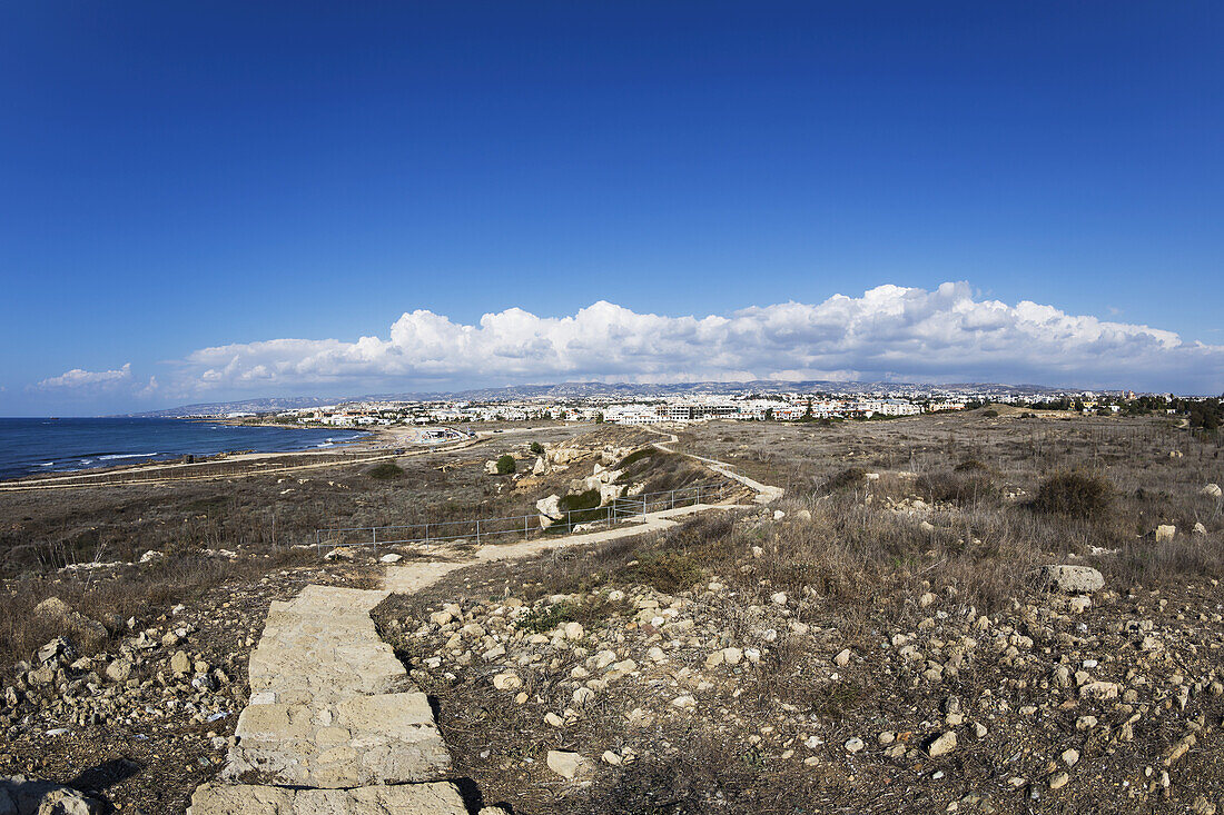 Ein zerklüfteter Steinpfad in einer kargen Landschaft am Rande des Wassers; Paphos, Zypern