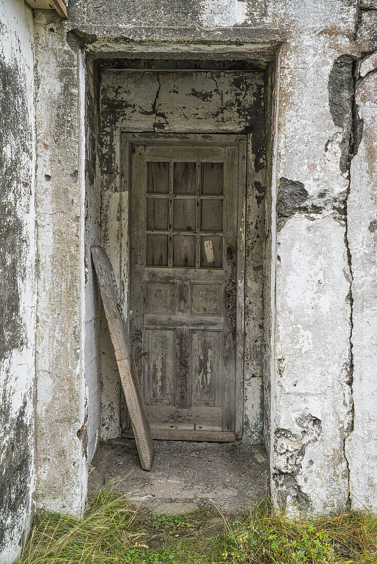 Eine alte Tür in einem verlassenen Gebäude in einem alten Fischerdorf; Djupavik, Island