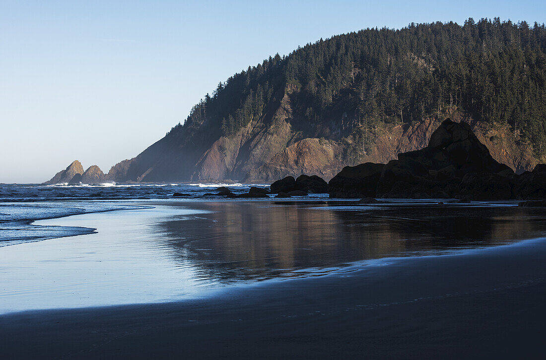 Das morgendliche Sonnenlicht erwärmt den Tillamook Head; Cannon Beach, Oregon, Vereinigte Staaten von Amerika