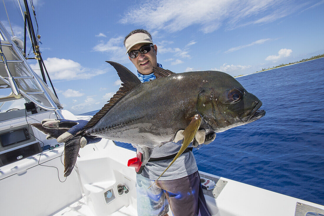 Fischer hält einen frisch gefangenen Jackfisch; Tahiti