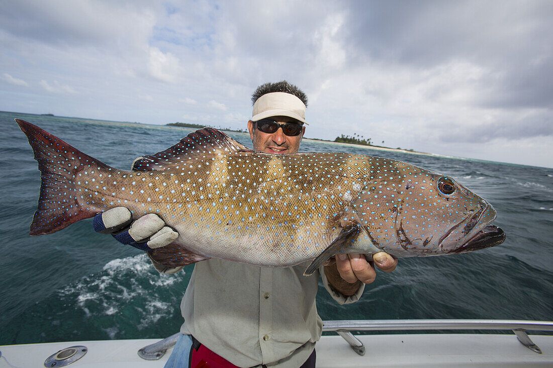 Fisherman Holding A Fresh Caught Grouper (Epinephelinae); Tahiti