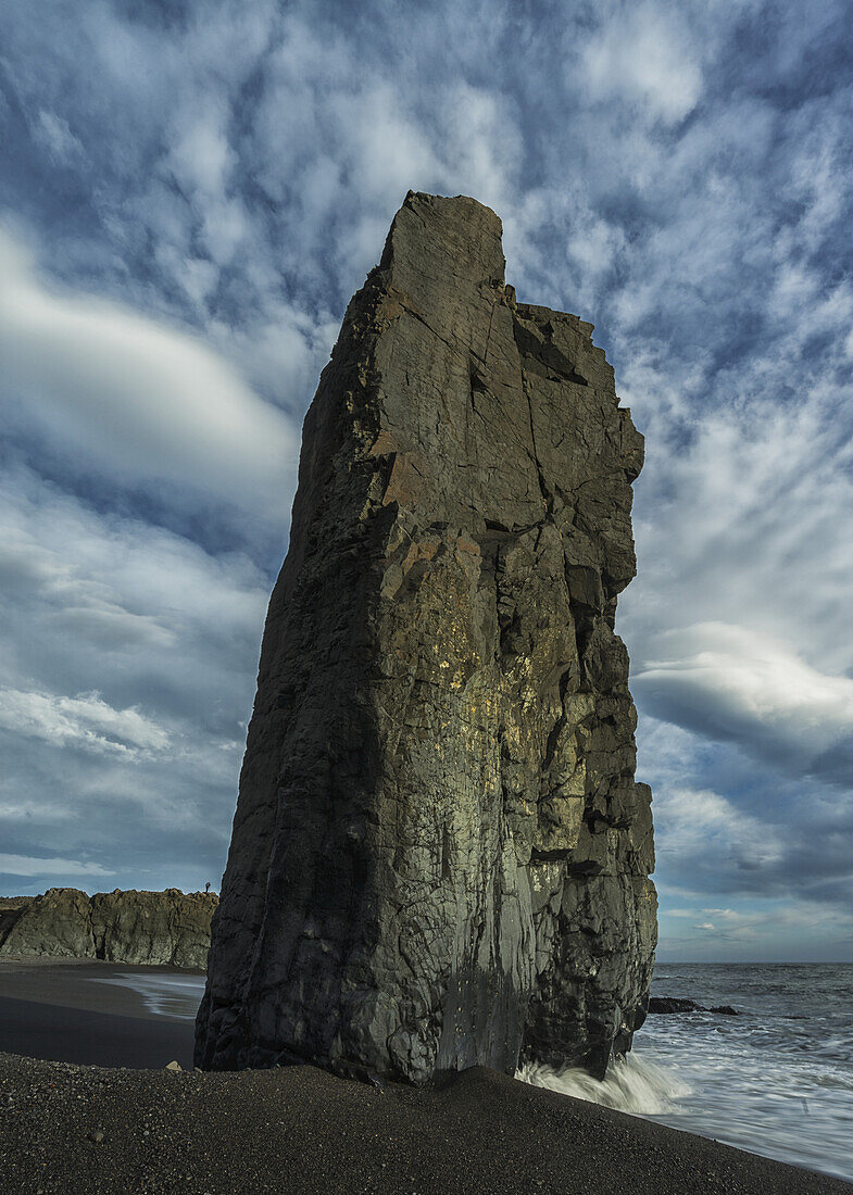 The Ocean Waves Crash Against A Large Seastack Along The Eastern Shore Of Iceland; Iceland