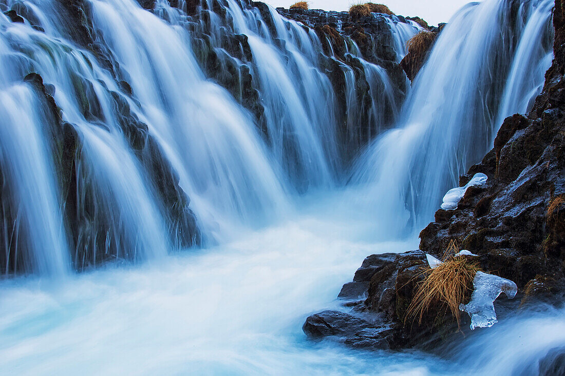 Wasserfälle, die über schroffe Felsklippen fließen; Bruarfoss, Island