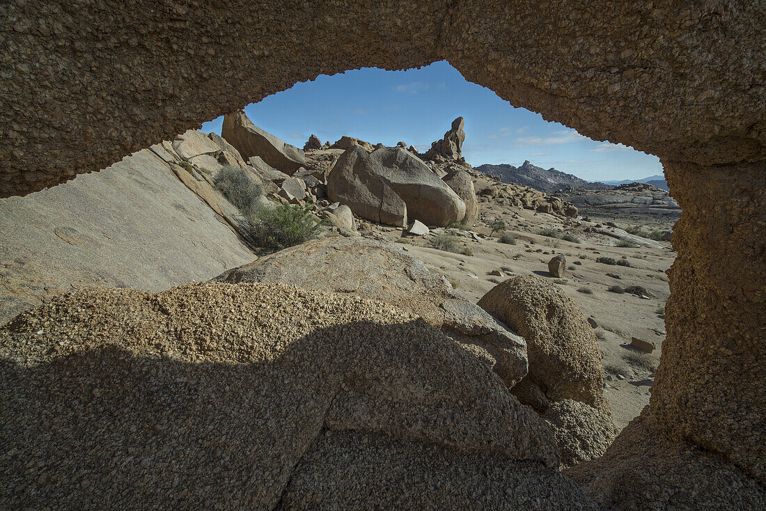 Blick durch ein Loch in den Felsen auf die Landschaft des Richtersveld-Nationalparks; Südafrika