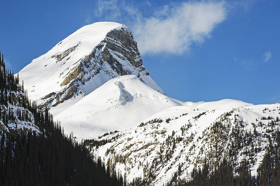 Close Up Of A Snow Covered Mountain Peak With Blue Sky And Clouds; Banff, Alberta, Canada