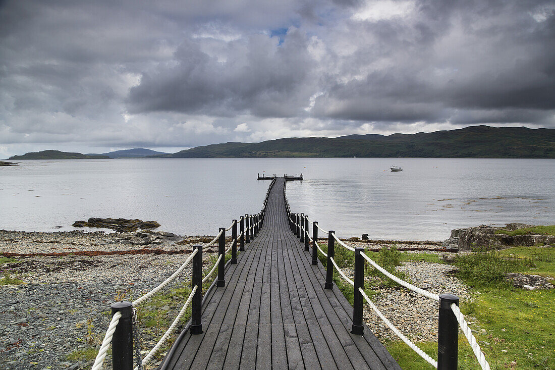 Wooden Walkway Leading Out To A Dock In The Water; Cumbria, England
